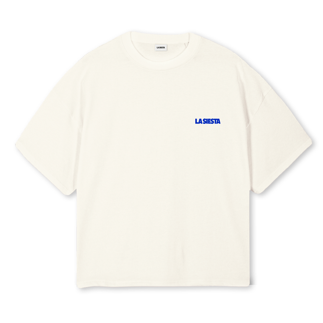 An off-white short-sleeve crewneck t-shirt with 'LA SIESTA' printed in blue text on the left chest, displayed against a solid white background.